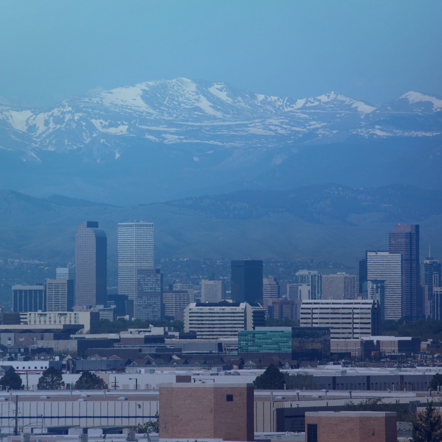 Aerial image of the city of Denver with Rocky Mountains looming in background